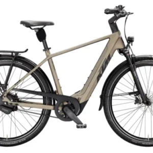 KTM MACINA CITY 810 BELT HE 2026 olive women's electric bike riding on a city street in Europe