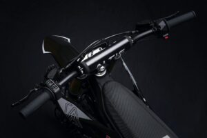 Altis Delta electric dirt bike performing a high jump on a rugged off-road trail in Europe.