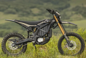 Sur Ron Light Bee-X electric dirt bike rider navigating a challenging forest trail in Europe.