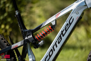 The 2023 Corratec E-Power iLink 180 Race electric mountain bike in a stunning Copper color, featuring an ultralight carbon frame, 180mm full suspension with iLink technology, Bosch CX Race motor, and a coil rear shock for extreme European freeride and enduro.